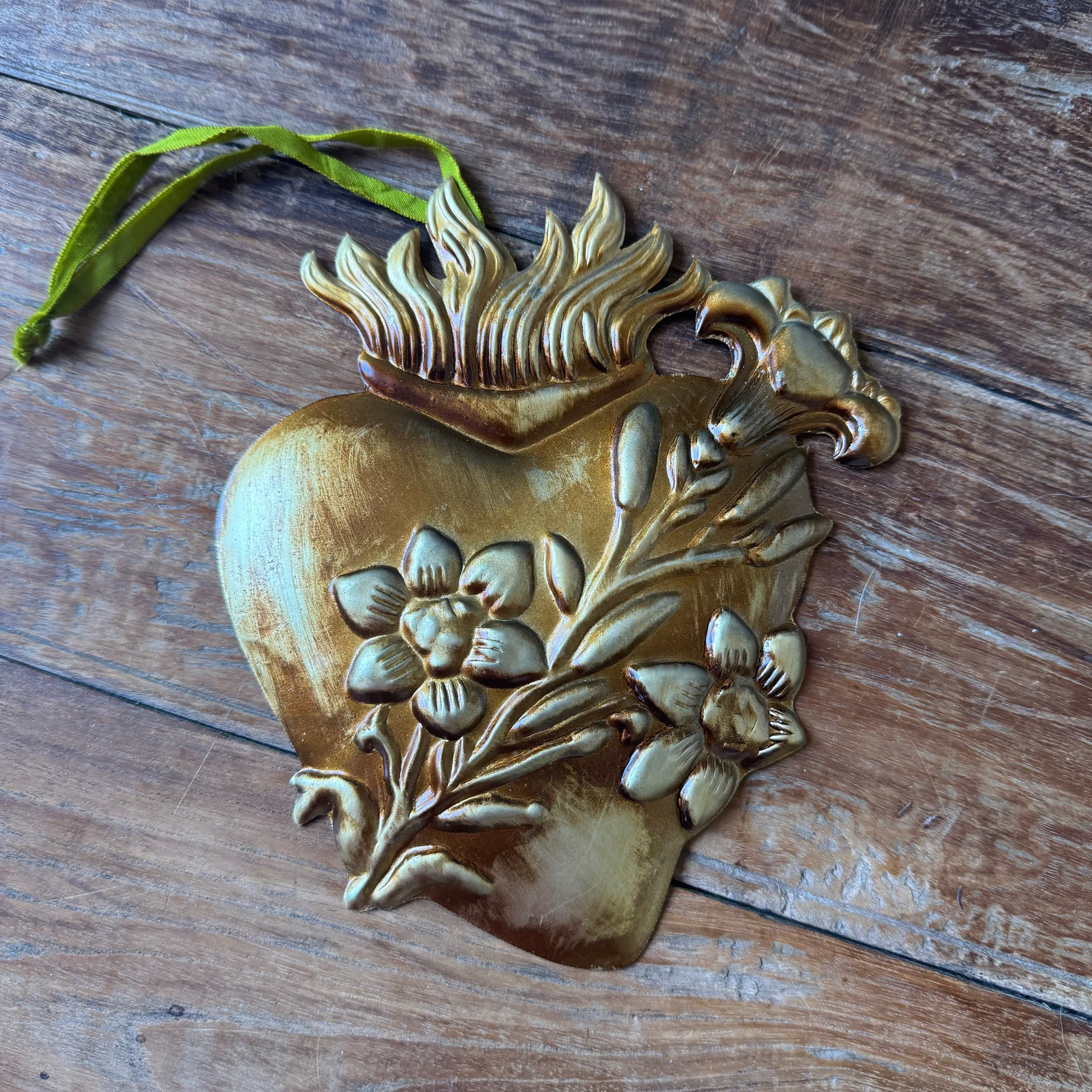 Decorative heart-shaped ornament with floral designs on a wooden surface