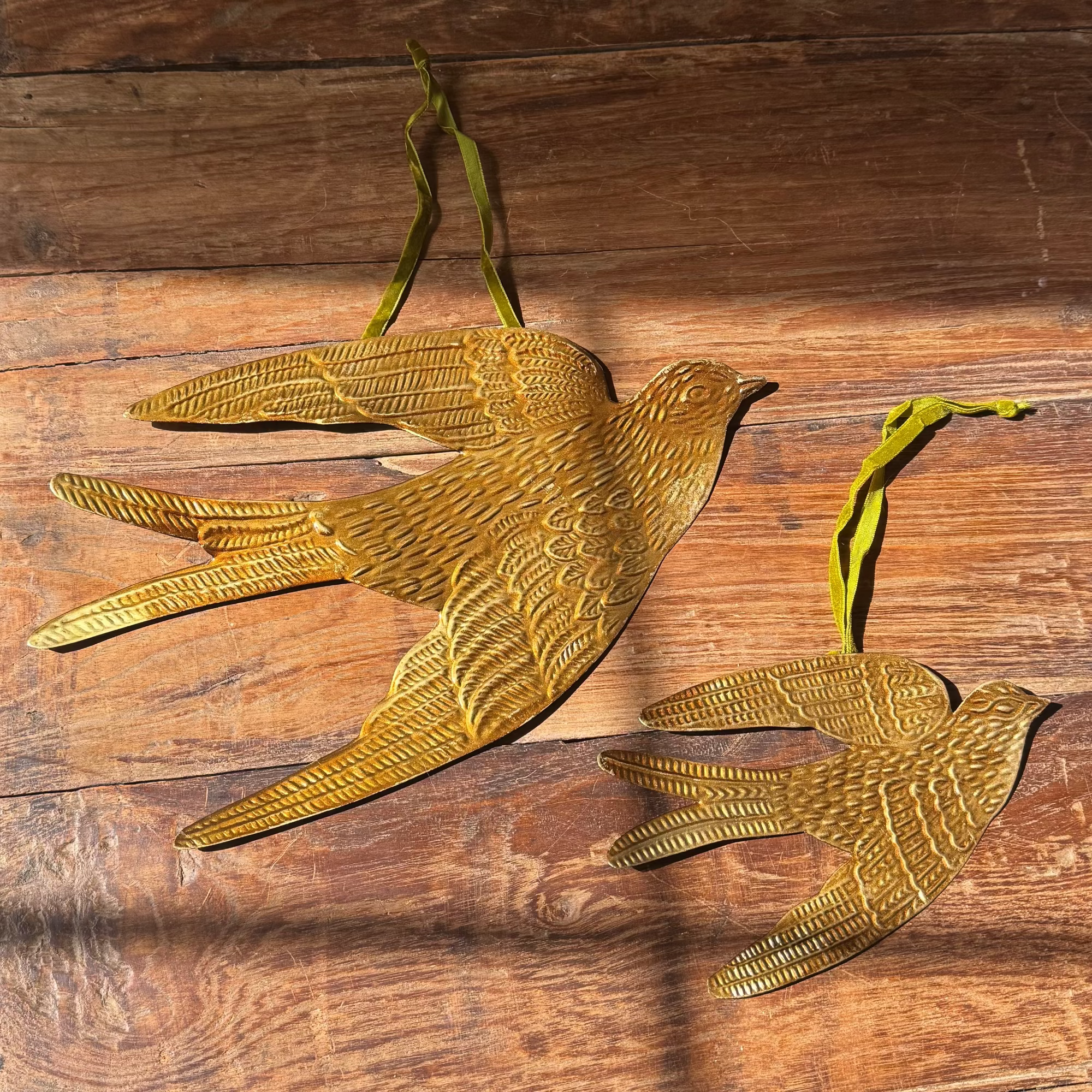 Gold bird-shaped decorative items on a wooden surface