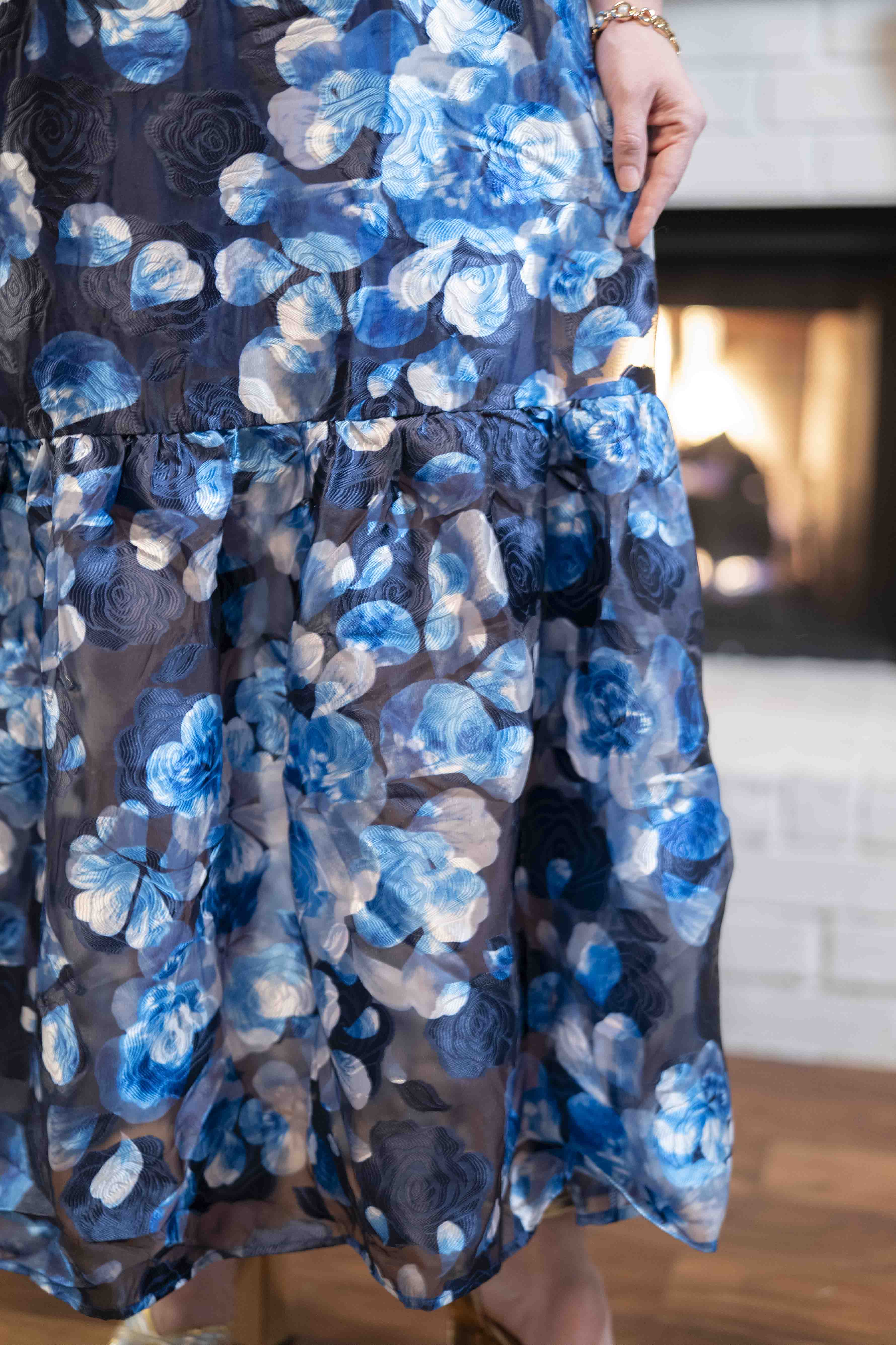 Close-up of a blue floral dress with a blurred indoor background