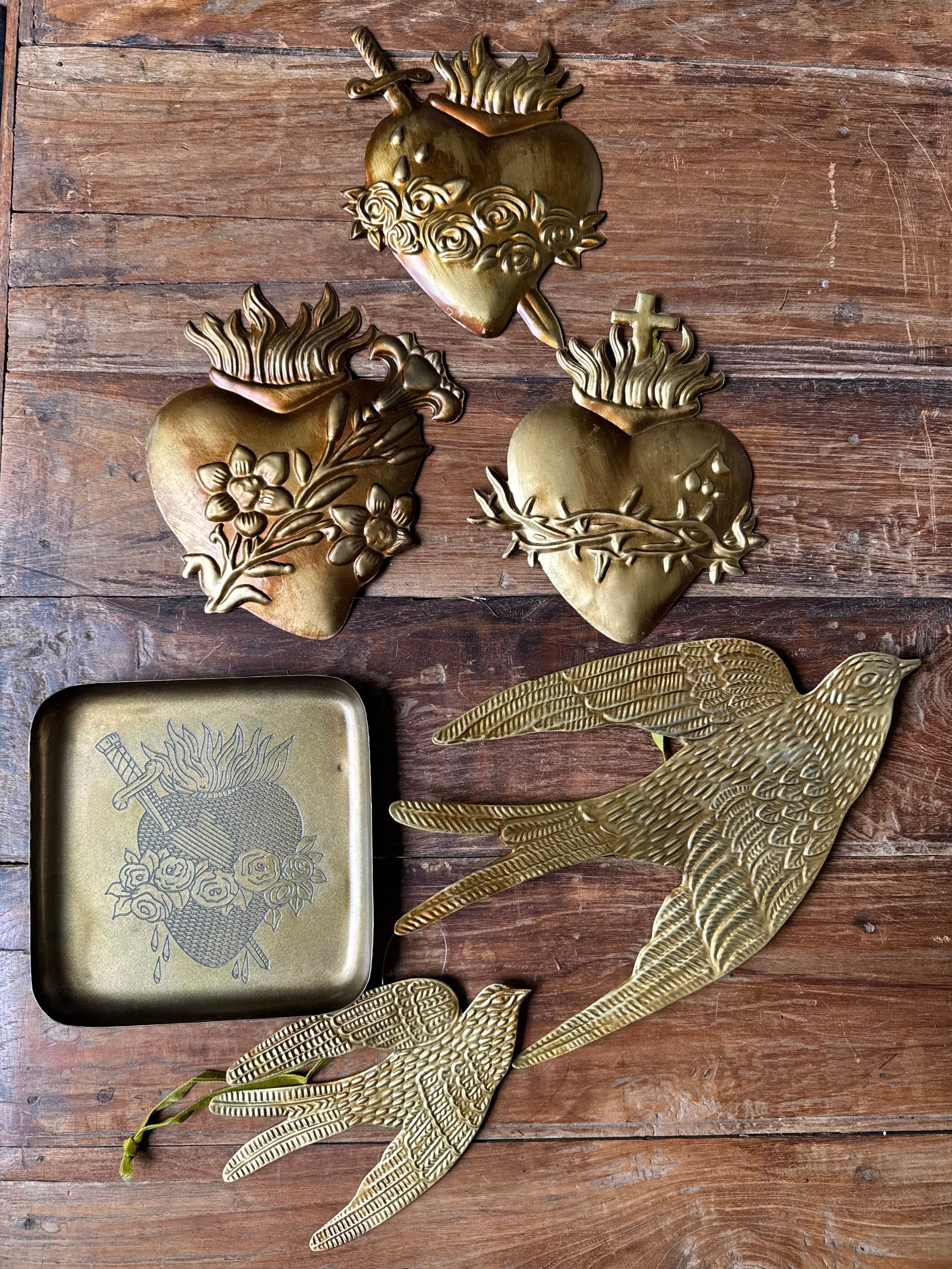 Decorative brass wall art pieces on a wooden surface